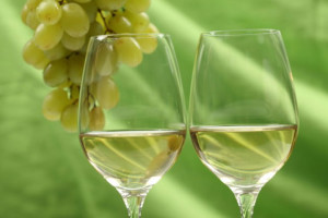 Bicchiere-di-vino-bianco-con-uva-sullo-sfondo