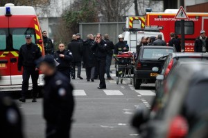 Police officers and firemen gather outside the French satirical newspaper Charlie Hebdo's office, in Paris, Wednesday, Jan. 7, 2015. Masked gunmen stormed the offices of a French satirical newspaper Wednesday, killing at least 11 people before escaping, police and a witness said. The weekly has previously drawn condemnation from Muslims. (AP Photo/Thibault Camus) [Credit: ANSA]