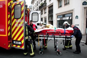 An injured person is transported to an ambulance after a shooting, at the French satirical newspaper Charlie Hebdo's office, in Paris, Wednesday, Jan. 7, 2015. Masked gunmen stormed the offices of a French satirical newspaper Wednesday, killing at least 11 people before escaping, police and a witness said. The weekly has previously drawn condemnation from Muslims. (AP Photo/Thibault Camus) [Credit: ANSA]